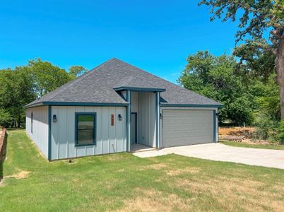 View of front facade featuring a garage and a front lawn