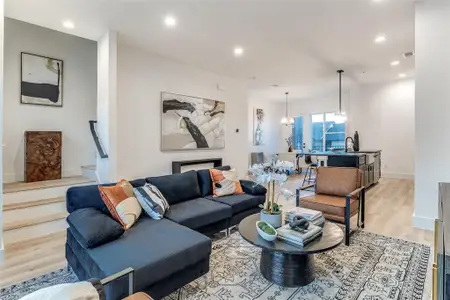 Living room with a notable chandelier and light hardwood / wood-style flooring