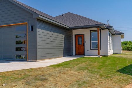 View of front facade featuring a front lawn and a garage