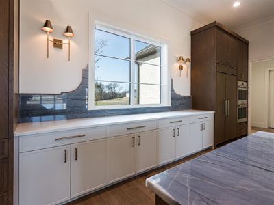 Kitchen window overlooks the front yard.  Designer backsplash, decorative lighting and hardware with ample storage space!