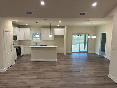 The open concept home features Luxury Vinyl Plank flooring recessed lighting.