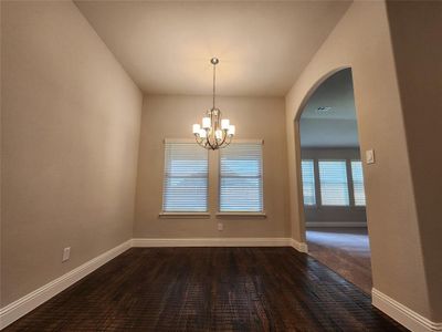 Unfurnished dining area with dark carpet and a notable chandelier