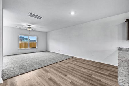 Unfurnished living room featuring light hardwood / wood-style flooring and ceiling fan