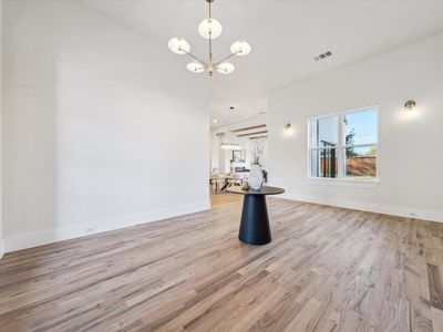 Unfurnished room with light hardwood / wood-style floors and a notable chandelier