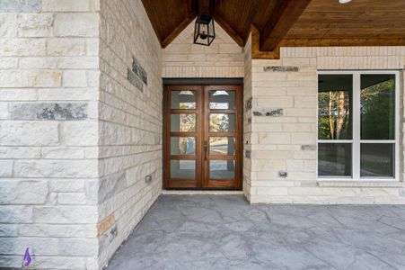 The front porch exudes charm, with its stone accents and ample space for rocking chairs or a bistro set.