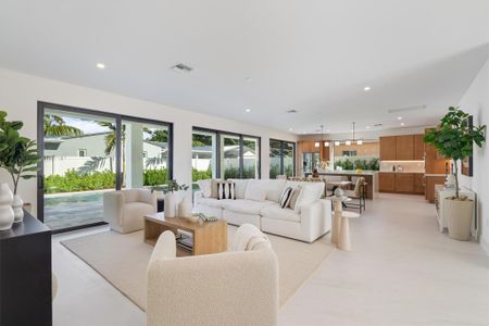 Open concept living area with glass sliders out to the patio and pool