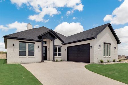 View of front of house with a front lawn and a garage