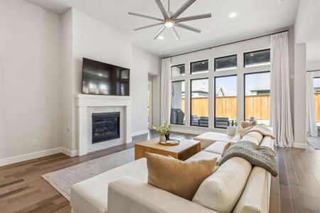 Living room featuring ceiling fan and dark wood-type flooring