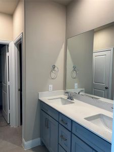 Full bath featuring double vanity, baseboards, and a sink