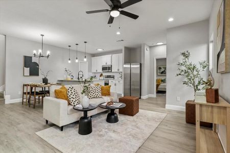 Living room with ceiling fan with notable chandelier, light hardwood / wood-style floors, and sink