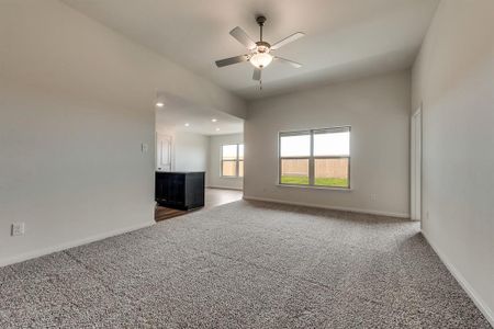 Unfurnished living room featuring carpet floors and ceiling fan