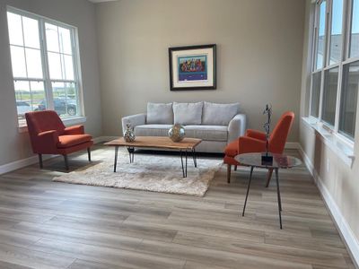 This living room space features an expansive, light-filled area with large windows and a versatile layout perfect for both entertaining and everyday living.