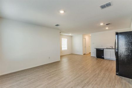 Unfurnished living room with light hardwood / wood-style floors and sink