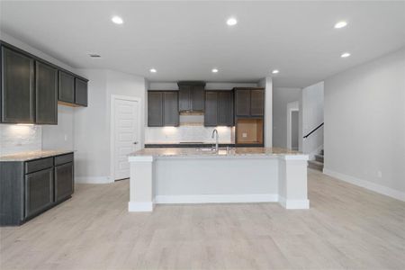 This kitchen is by far any chef’s dream! This spacious kitchen features high ceilings, stained wood cabinets, quartz countertops, SS appliances, modern tile backsplash, recessed lighting, quartz kitchen island with space for breakfast bar and extra storage, and a walk-in pantry all overlooking your huge family room.