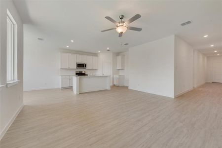 Unfurnished living room with light wood-type flooring and ceiling fan