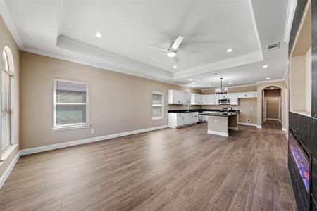 Kitchen featuring dark countertops, a raised ceiling, stainless steel microwave, and visible vents