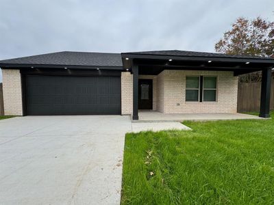 View of front of home with a front yard and a garage