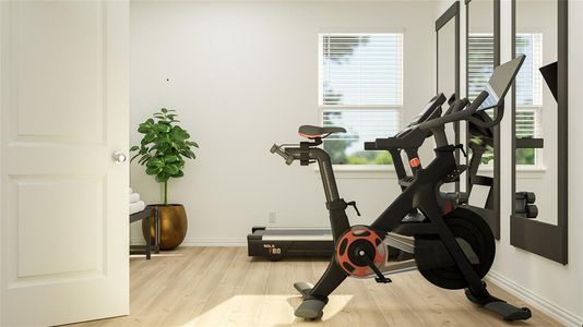 Workout area with light wood-style flooring and baseboards