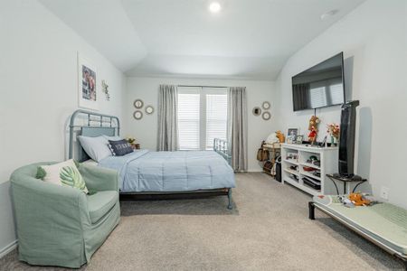 Bedroom with carpet floors, baseboards, and vaulted ceiling