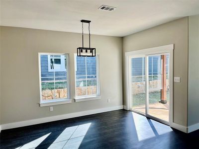 Dining area with an inviting chandelier, a healthy amount of sunlight, and dark hardwood / wood-style flooring