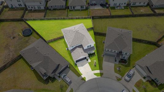 Aerial view showcasing the home's oversized cul-de-sac lot with luscious landscaping and double-wide driveway.