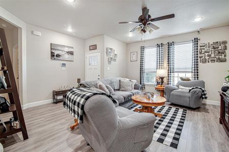 Living room featuring light hardwood / wood-style flooring and ceiling fan