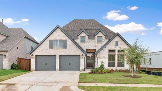 View of front of house with a garage and a front yard