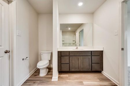 Bathroom with hardwood / wood-style floors, vanity, and toilet