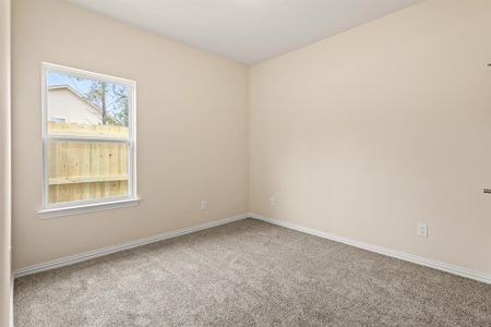 Carpeted spare room with baseboards