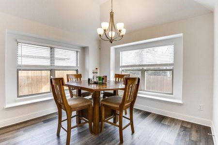 The dining area is open to the kitchen and living room, features a door to the covered back patio, has decorative lighting and receives lots of natural light.