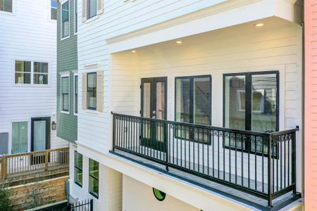 The property features a modern  balcony with elegant black railings and large windows, offering a  stylish and inviting outdoor space  outside of the main living area.