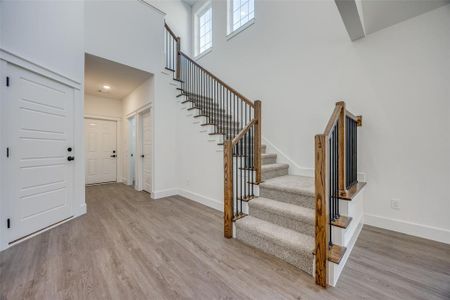 Stairs featuring a high ceiling and hardwood / wood-style flooring