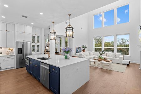 Kitchen with blue cabinets, sink, white cabinetry, an island with sink, and stainless steel appliances