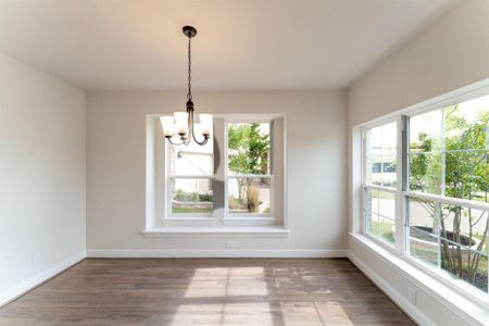 Unfurnished dining area with a chandelier, dark hardwood / wood-style flooring, and a wealth of natural light