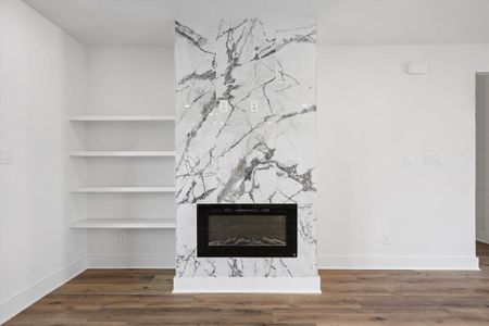 Interior details with a fireplace, built in shelves, and luxury vinyl flooring