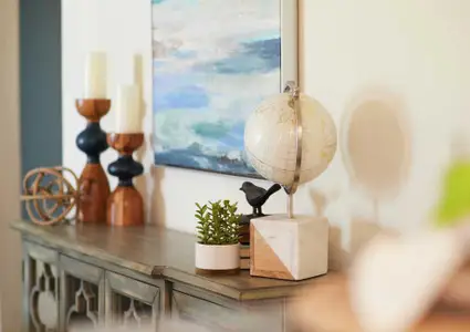 Living room decor with white globe, candles and brown dresser.