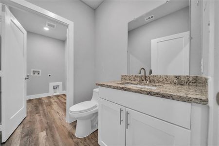 Bathroom with vanity, hardwood / wood-style floors, and toilet