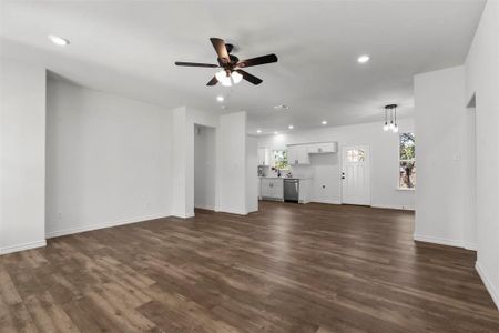 Unfurnished living room with dark hardwood / wood-style floors and ceiling fan