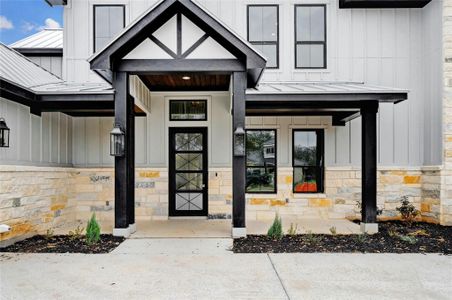 Property entrance featuring board and batten siding, a standing seam roof, and stone siding