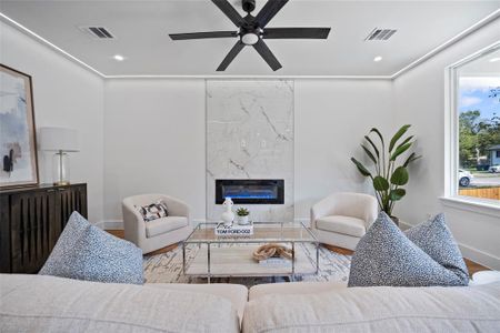 Living room featuring ceiling fan, hardwood / wood-style flooring, and a fireplace