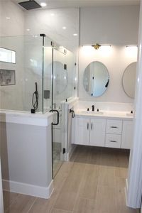 Bathroom featuring a shower with door and vanity