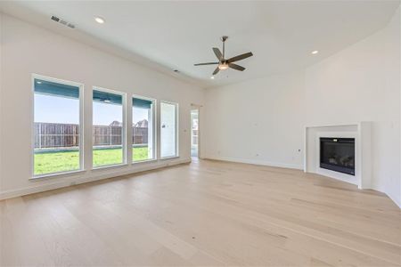 Unfurnished living room with ceiling fan and light hardwood / wood-style flooring