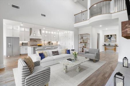 Living room with a towering ceiling and light wood-type flooring