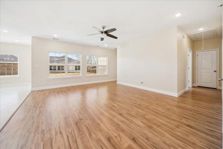 Unfurnished living room featuring ceiling fan and light hardwood / wood-style flooring