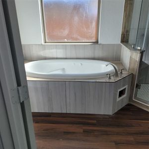 Bathroom featuring plus walk in shower and hardwood / wood-style floors