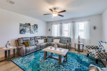 Living room featuring wood-type flooring and ceiling fan