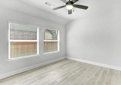 Flex room with large windows, wood flooring, and a ceiling fan.