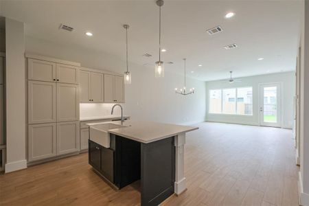 The open concept flows from the kitchen through the dining area into the large living room overlooking the back yard.