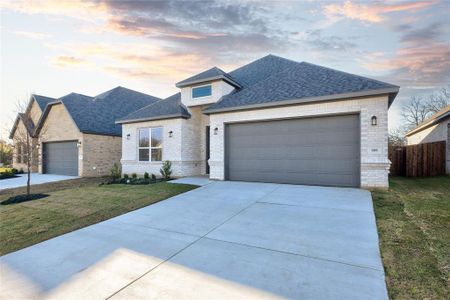 View of front facade with a garage and a lawn