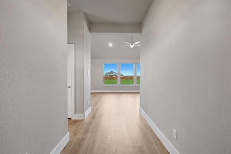 Hall with a high ceiling and light hardwood / wood-style floors